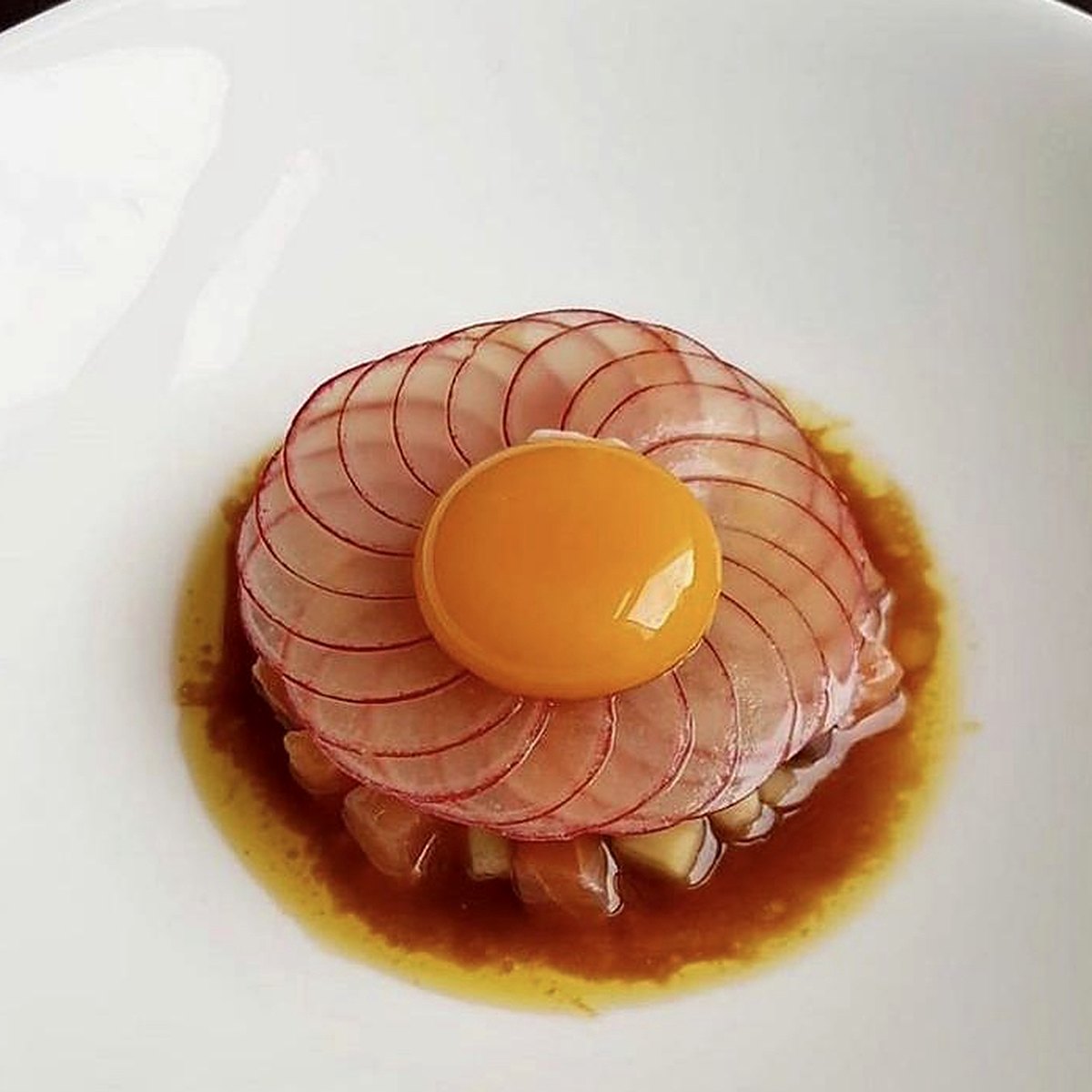 Fish tartare under a radish rosette with cured yolk