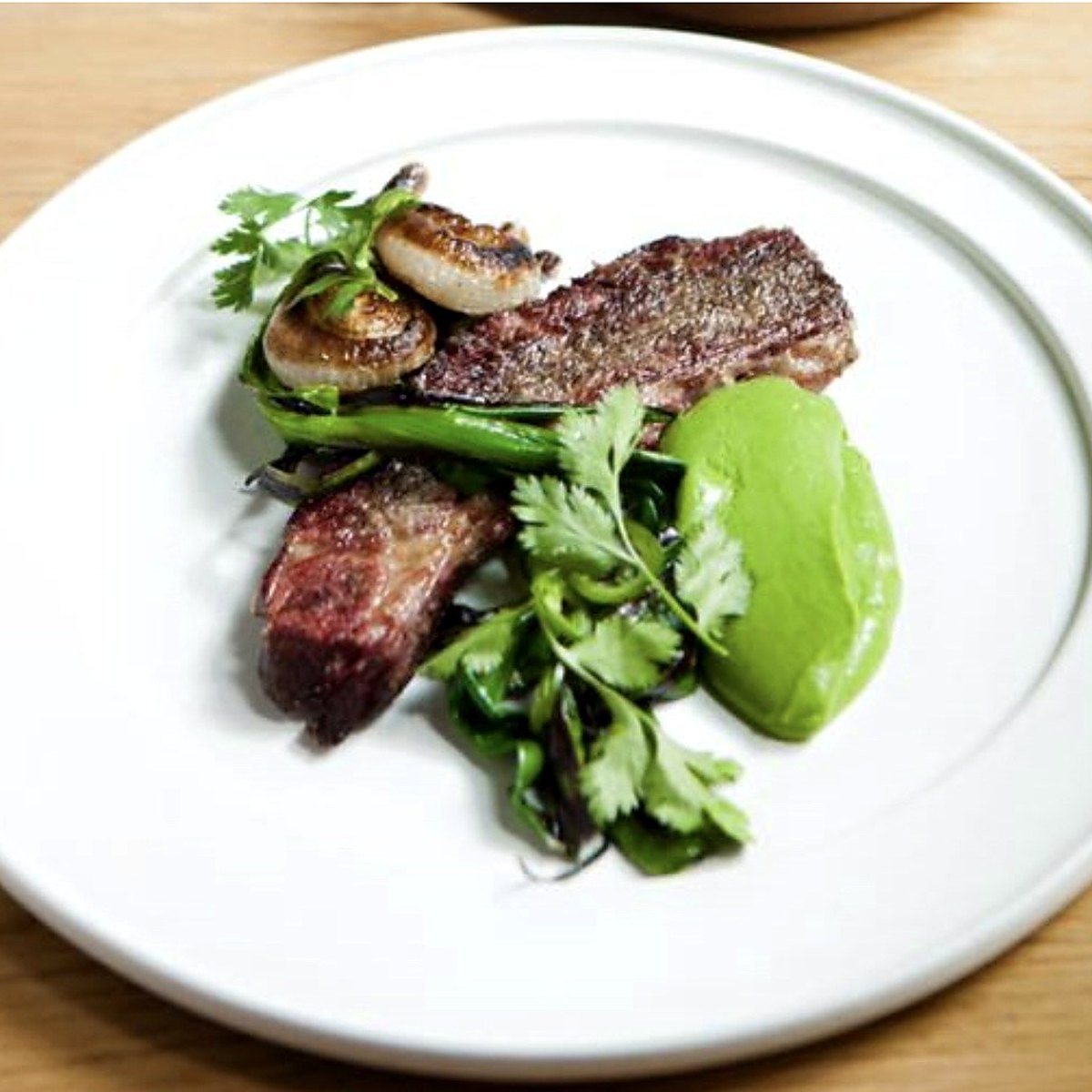 Grilled beef with herb purée and charred onion